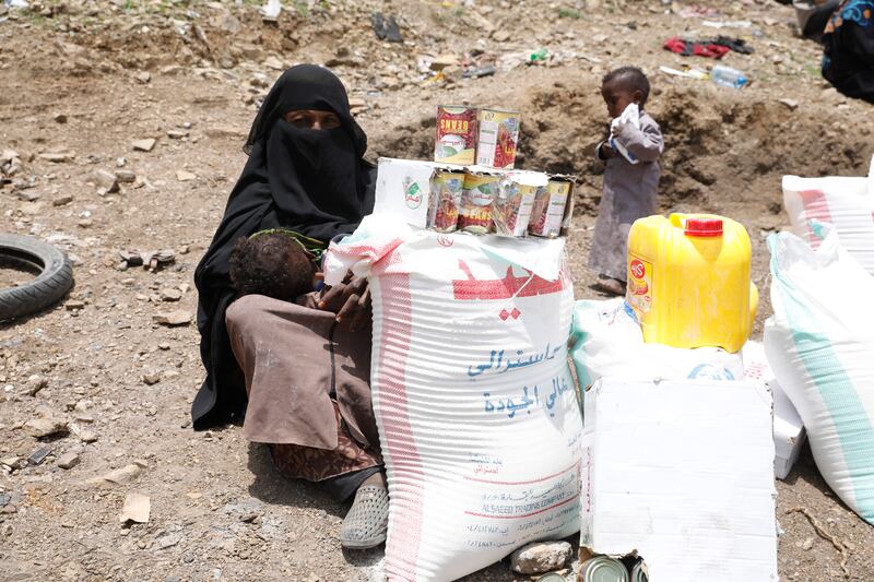 A displaced Yemeni woman receives emergency food on the outskirts of Sanaa, Yemen. EPA