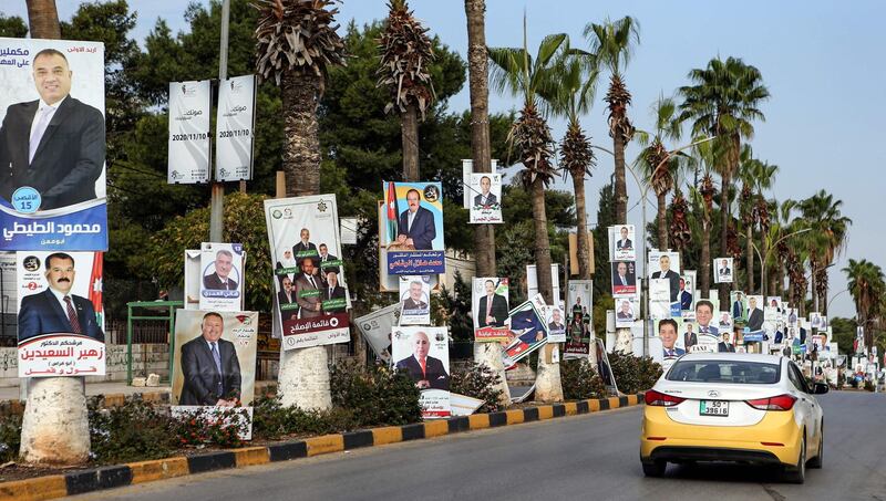 A taxi drives past electoral banners for candidates and lists running in the 2020 general election in Jordan. AFP