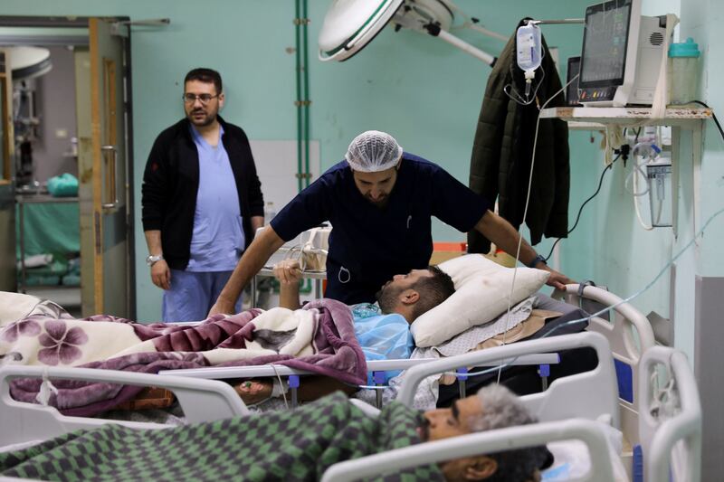Palestinian-Irish plastic surgeon Ahmed El Mokhallalati checks in on a Palestinian man wounded in an Israeli strike, at the European Hospital, in Khan Younis. Reuters