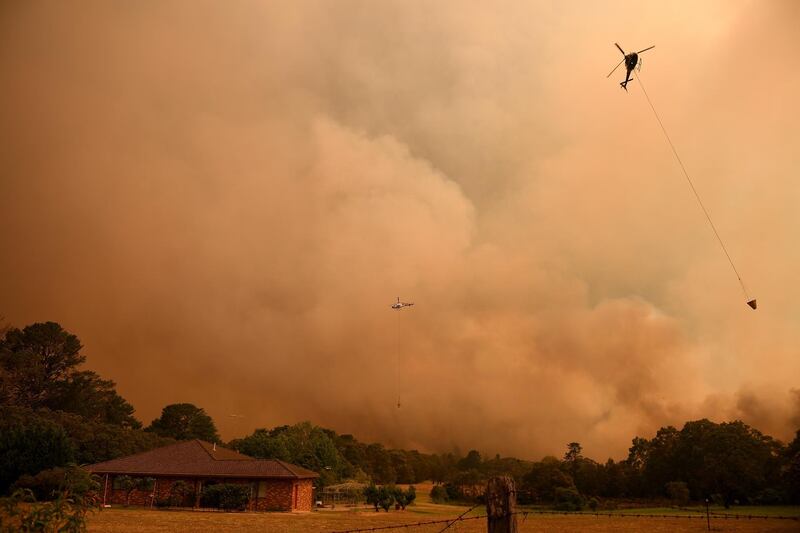 A firefighting helicopter in action as the Grose Valley Fire approaches Kurrajong Heights, NSW.  EPA