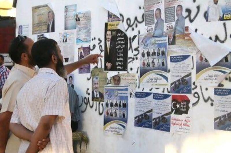 Men in Benghazi inspect campaign posters. Many Libyans in this region fear that a concentration of seats around Tripoli will see them discriminated against and have called for autonomy for eastern Libya.