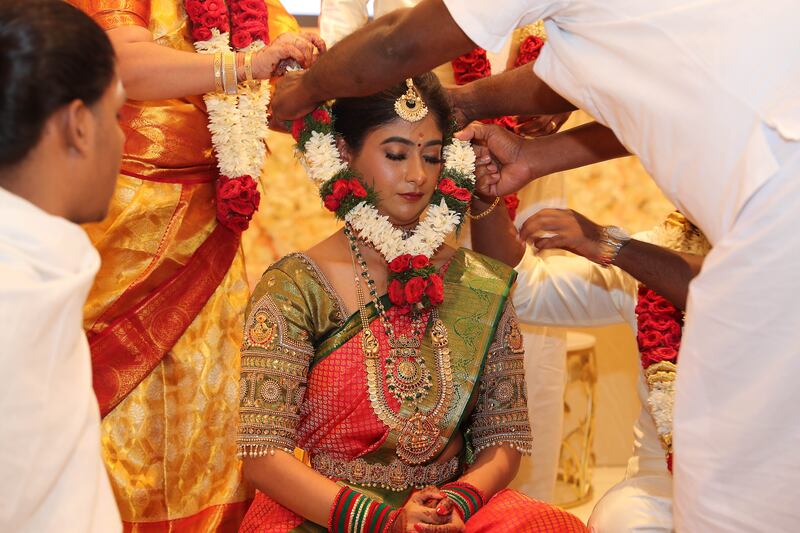 A garland of flowers is placed on the bride's neck as part of the ceremony