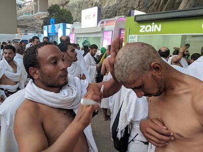 A man cuts the hair of a pilgrim in Makkah, Medina.