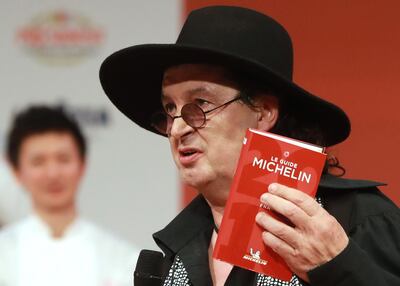 (FILES) In this file photo taken on February 5, 2018 French chef Marc Veyrat, holds a Michelin guide after being awarded the maximum three Michelin stars, during the Michelin guide award ceremony at La Seine Musicale in Boulogne-Billancourt near Paris. Veyrat filed a claim against Michelin after losing his three Michelin stars award, AFP reports on September 23, 2019.  / AFP / JACQUES DEMARTHON

