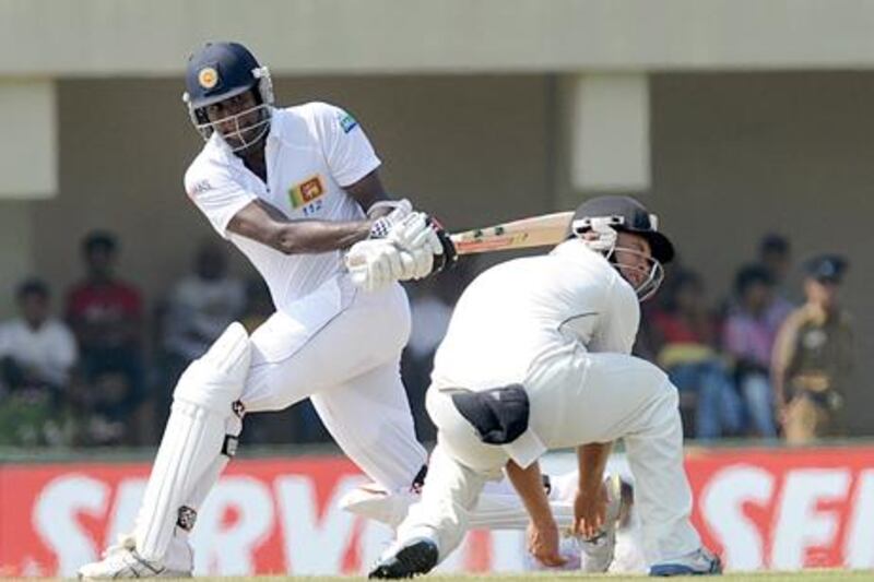 Sri Lanka batsman Angelo Mathews plays a shot ahead of New Zealand's Daniel Flynn.