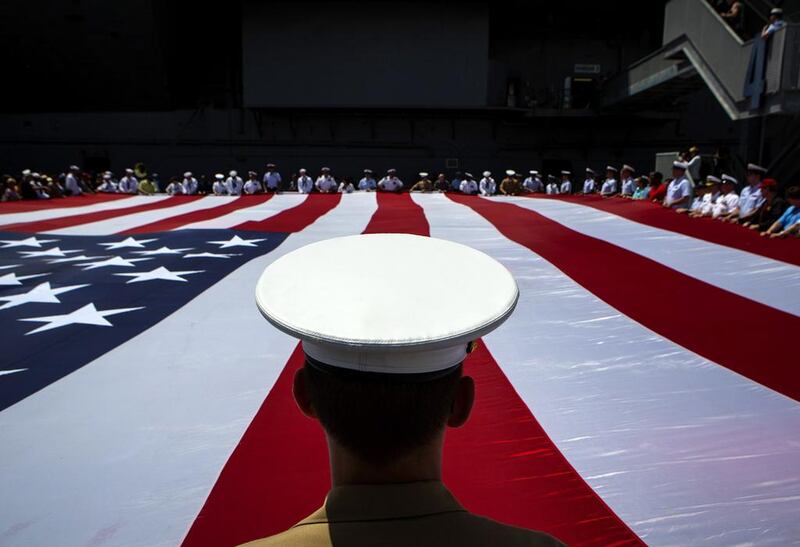 Members of the military unfurl an American flag during a wreath-laying ceremony at the Intrepid Sea, Air & Space Museum in New York City. Eric Thayer / Getty