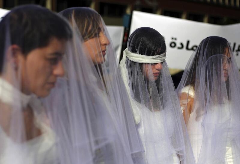 About a dozen Lebanese women – dressed as brides in white wedding gowns stained with fake blood and bandaging their eyes, knees and hands – stand in front of the government building in Beirut, Lebanon, on December 6, 2016 to protest against a Lebanese law that allows a rapist to get away with his crime if he marries his victim. Bilal Hussein/AP Photo