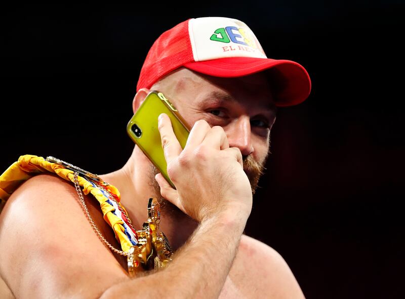 Tyson Fury speaks on his phone during a press conference after winning the fight against Deontay Wilder. Reuters