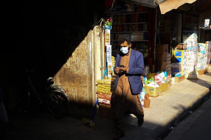 An Afghan man wearing a protective facemask walks in a market in Herat city.  AFP