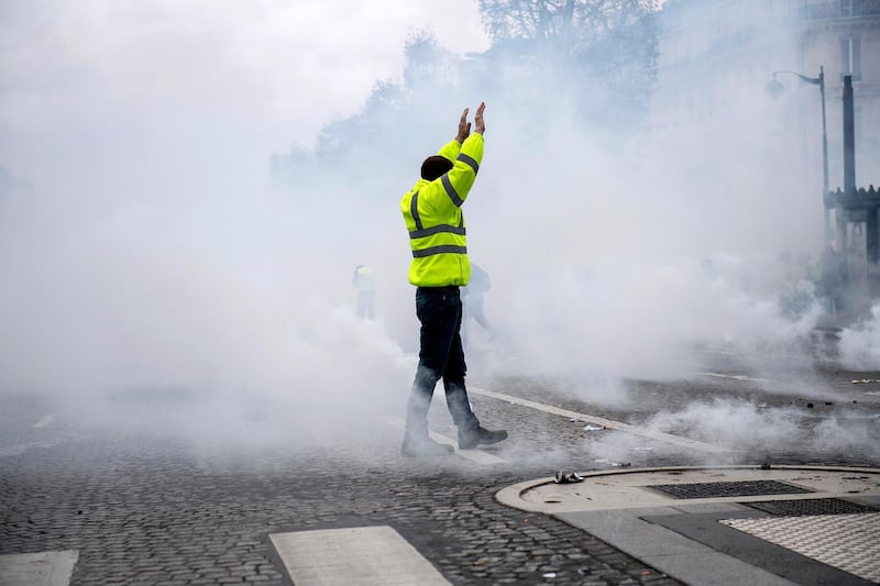epaselect epa07216917 A yellow vest protester stands amid smoke during a demonstration in Paris, France, 08 December 2018. Police in Paris is preparing for another weekend of protests of the so-called 'gilets jaunes' (yellow vests) protest movement. Recent demonstrations of the movement, which reportedly has no political affiliation, had turned violent and caused authorities to close some landmark sites in Paris this weekend.  EPA/JULIEN DE ROSA