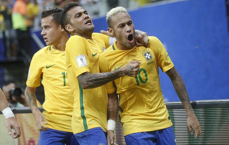 Neymar, right, celebrates with teammates after scoring the winning goal against Colombia. Andre Penner / AP Photo