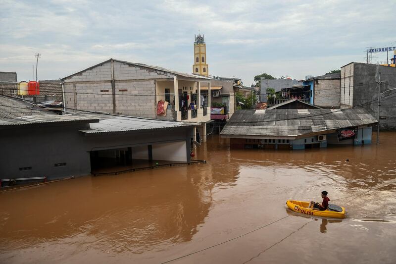 A man uses an inflatable boat as floods hit in Jakarta, Indonesia. Reuters