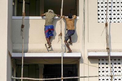 Workers work on MHADA (Maharashtra Housing and Area Development Authority)  residential low cost building as it  stand the Kurla area in Mumbai, India, on Sunday, Jan. 28, 2018.Photographer: Dhiraj Singh/Bloomberg