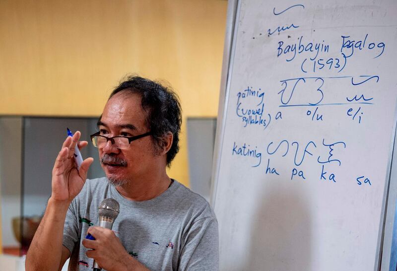 This photo taken on July 6, 2019 shows cultural advocate Leo Emmanuel Castro teaching students the indigenous script known as Baybayin, used before Spanish colonisation in 1521, in Manila.