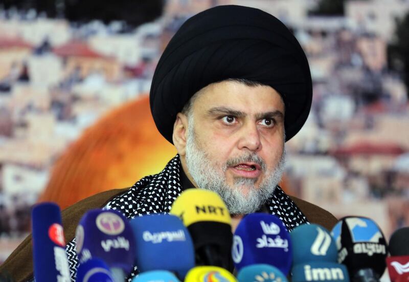 Iraq's powerful Shiite cleric Moqtada al-Sadr addresses the media with a giant photo of Jerusalem's Dome of the Rock mosque in the background in the shrine city of Najaf in central Iraq on December 7, 2017 to denounce US President Donald Trump's decision to recognise Jerusalem as Israel's capital. 
Sadr, who heads his own militia, demanded the closure of the American embassy in Baghdad and warned that "we can reach Israel through Syria". / AFP PHOTO / Haidar HAMDANI