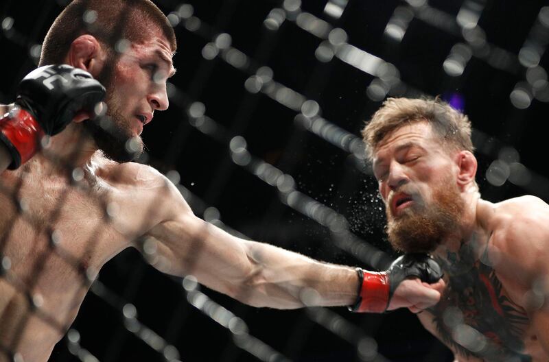 Khabib Nurmagomedov, left, punches Conor McGregor during a lightweight title mixed martial arts bout at UFC 229 in Las Vegas, Saturday, Oct. 6, 2018. (AP Photo/John Locher)