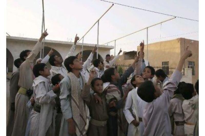 Members of the Abida tribe point to the sky as they look for a drone aircraft flying at very high altitude over Wadi Abida, in the eastern Yemeni province of Maarib. Khaled Abdullah / Reuters