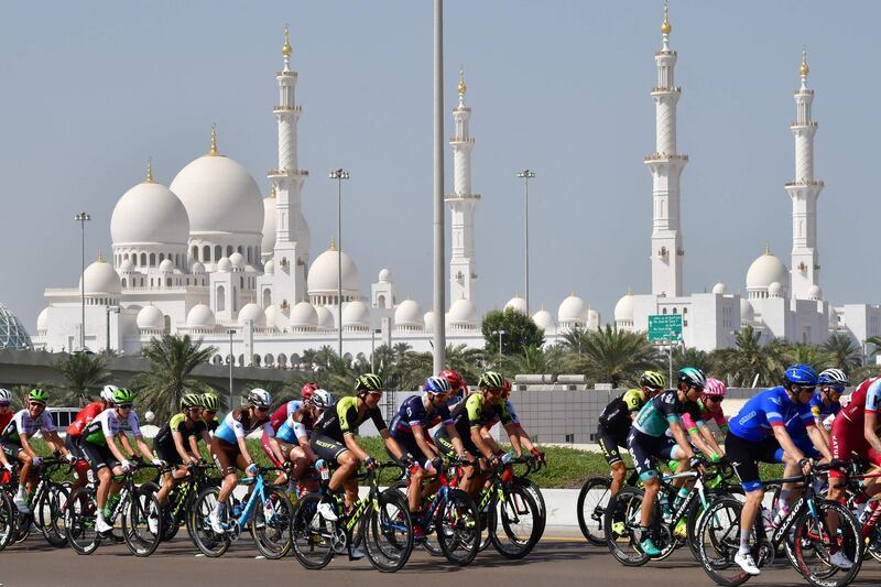 TOPSHOT - The peloton rides past Sheikh Zayed Grand Mosque during the third stage of the 2018 Abu Dhabi cycling tour in the Emirati capital on February 23, 2018. / AFP PHOTO / GIUSEPPE CACACE