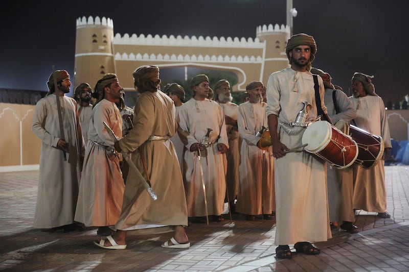 Men wait to perform a sword-dance during the annual summer monsoon festival in Salalah.