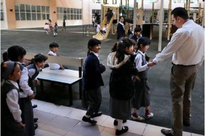 Students greet their teacher during an outside break at the Emirates National Schools.