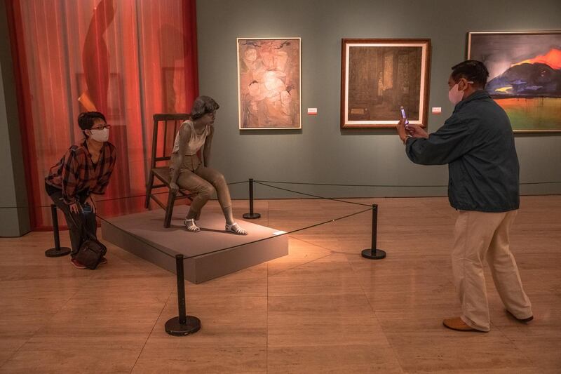 A museum goers snaps a photo of an artwork at the National Art Museum of China on the first day after reopening.  EPA