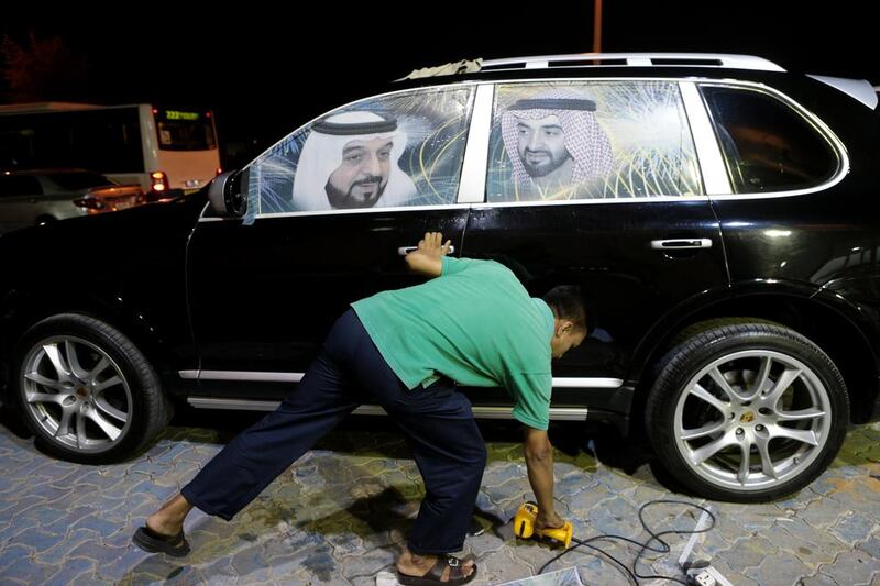 Sedra Car Decoration in Al Shahama was busy applying photos of UAE leaders to cars for National Day yesterday. Christopher Pike / The National