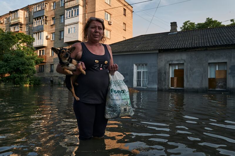 A woman walks along a flooded street in Kherson. AP