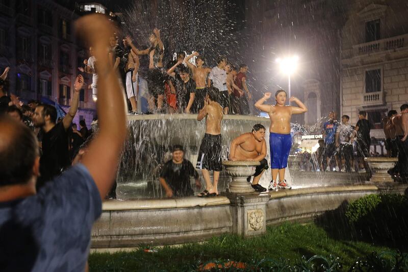 Napoli's supporters celebrate on a public fountain in Naples. AFP