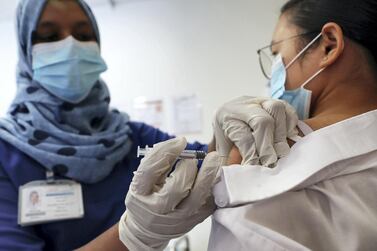 DUBAI, UNITED ARAB EMIRATES , September 16 – 2020 :- Resy Hussain, Nurse giving the Flu vaccine shot to Flora Mae (patient) at the Prime Hospital in Dubai. (Pawan Singh / The National) For News/Online. Story by Nick Webster