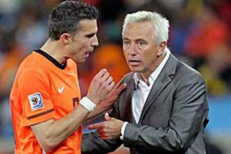 Bert van Marwijk, right, the Holland coach, tries to calm Robin van Persie down after the Dutch striker was substituted against Slovakia.