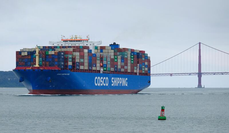 FILE - In this May 14, 2019 file photo, a Cosco Shipping container ship passes the Golden Gate Bridge in San Francisco bound for the Port of Oakland. For major shipping companies dealing with trade wars and a slowing global growth, conditions appear to have deteriorated as 2019 came to a close.  Global shipping and logistics provider Expeditors International said Friday, Jan. 17, 2020 that it expects fourth quarter operating income to fall between $177 million and $183 million.  (AP Photo/Eric Risberg, File)