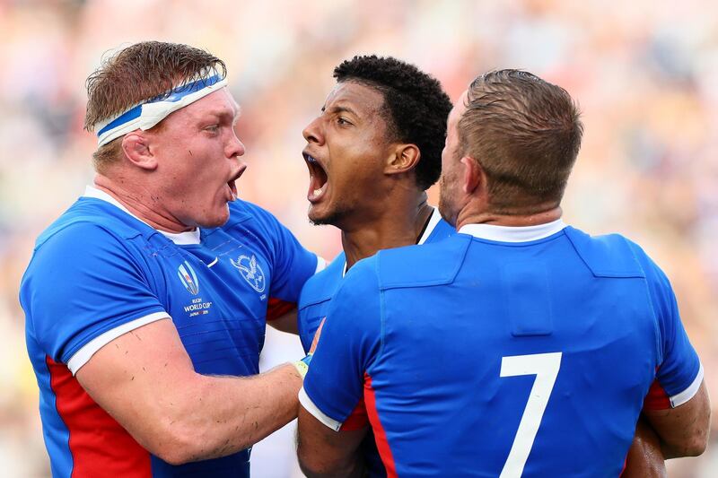 Chad Plato, centre, of Namibia celebrates scoring his side's third try against Italy. Getty Images