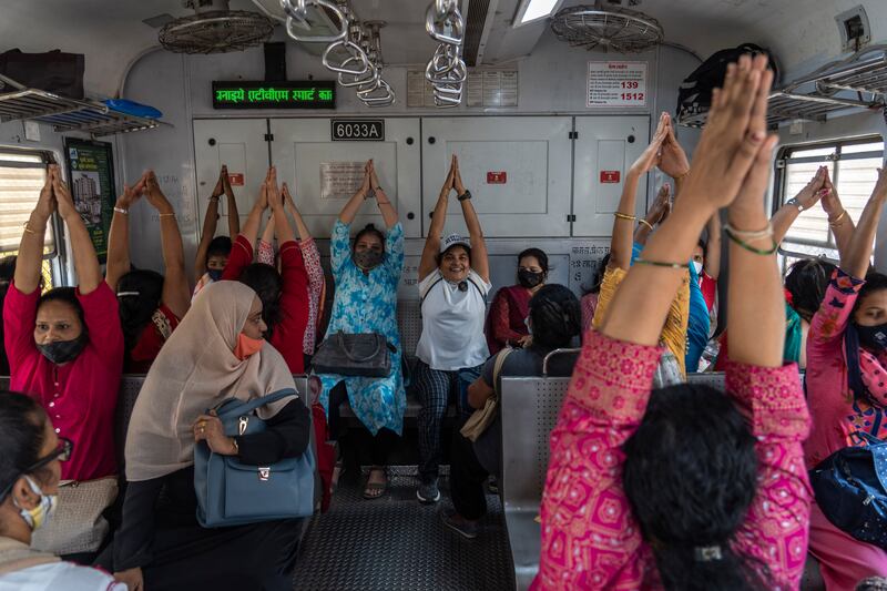 Commuters in a suburban train take part in a yoga session held to mark the International Women's Day in Mumbai, India.  AP Photo