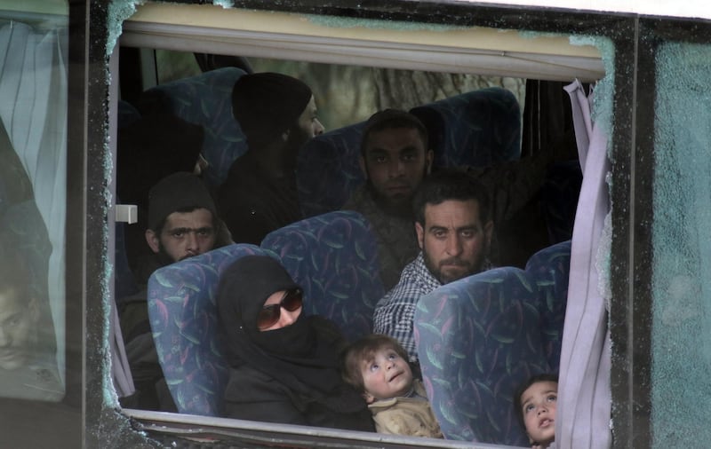 epa06625214 People sit in a government chartered coach carrying fighters and their families from the besieged city of Harasta are on their way to the northwestern city of Idlib, Syria, 23 March 2018 in accordance with an agreement with the Syrian government to surrender in exchange for getting safe way to Idlib. According to media reports, some 50 coaches left Harasta on 23 March 2018 with 2,806 on board, including 990 gunmen and 111 leaders of armed groups. The reports said that there were 10 busses remaining to complete the evacuation process and declare Harasta as a city free of armed presence.  EPA/YOUSSEF BADAWI