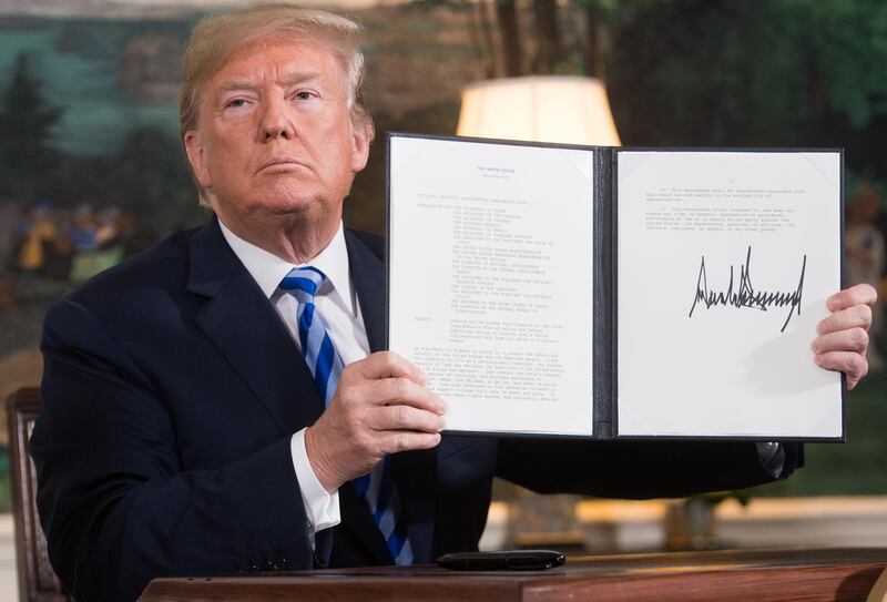 US President Donald Trump signs a document reinstating sanctions against Iran after announcing the US withdrawal from the Iran Nuclear deal, in the Diplomatic Reception Room at the White House in Washington, DC, on May 8, 2018. (Photo by SAUL LOEB / AFP)