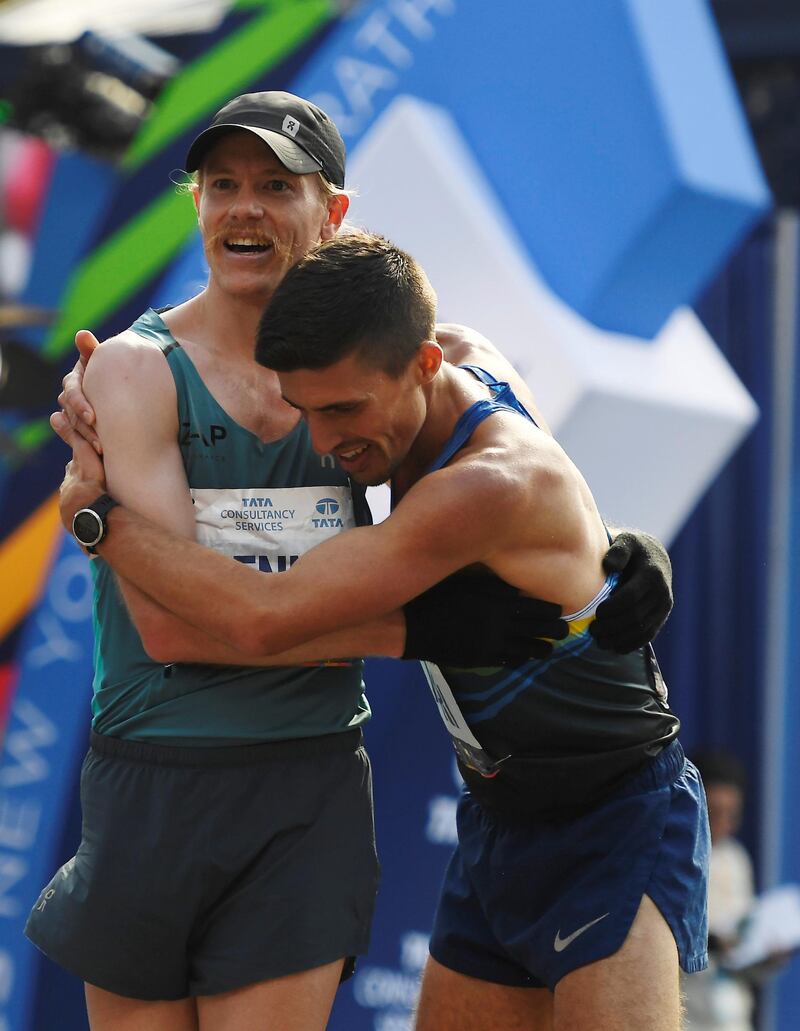 NEW YORK, NEW YORK - NOVEMBER 03: Tyler Pennel of the United States, left, embraces John Raneri of the United States after crossing the finish line for the Men's Division of the 2019 TCS New York City Marathon on November 03, 2019 in New York City.   Sarah Stier/Getty Images/AFP