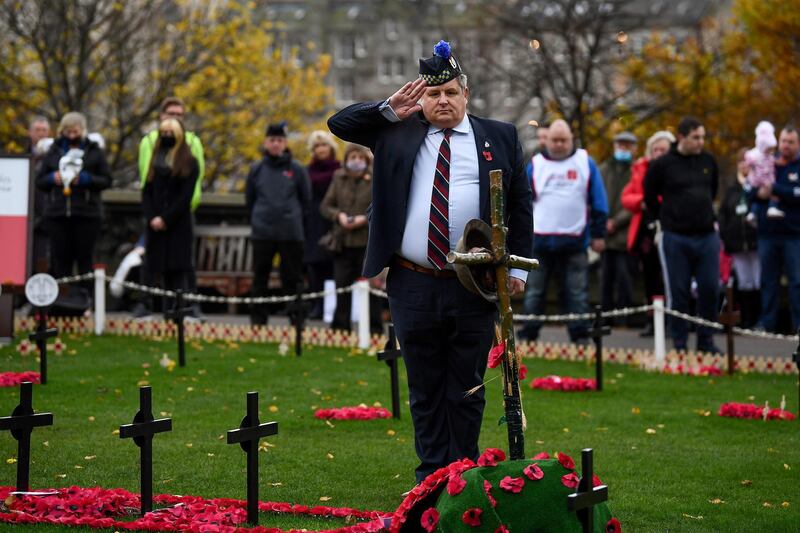 Members of the public observe a two-minute silence in the Garden of Remembrance in Edinburgh, Scotland. Getty Images