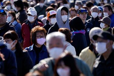 Spectators wait to see the Olympic flame display ceremony in Iwaki, Fukushima, the day after the Tokyo Olympics were delayed for a year. AP