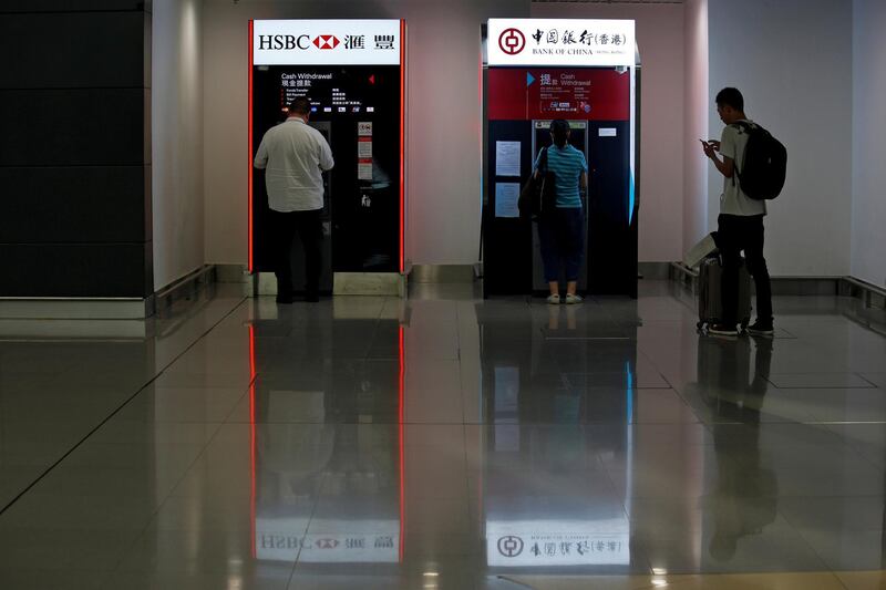 FILE PHOTO: People use HSBC and Bank of China ATM machines at Hong Kong Airport in Hong Kong, China September 5, 2017. REUTERS/Bobby Yip/File Photo