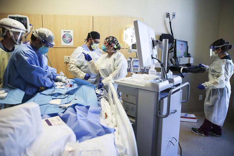 LOS ANGELES, CALIFORNIA - FEBRUARY 17: (EDITORIAL USE ONLY) Clinicians perform a tracheostomy on a patient in a COVID-19 ICU (Intensive Care Unit) at Providence Holy Cross Medical Center in the Mission Hills neighborhood on February 17, 2021 in Los Angeles, California. The hospital is located in the northeast San Fernando Valley, which was a primary coronavirus hotspot in hard hit Los Angeles County. The patient population is predominantly Latinx. In the US overall, Latinos are 3.2 times more likely to have been hospitalized as whites due to COVID, according to the latest CDC data. Increased chances of exposure to the virus, social determinants of health, economic and systemic inequities all contribute to heightened coronavirus risk.   Mario Tama/Getty Images/AFP
== FOR NEWSPAPERS, INTERNET, TELCOS & TELEVISION USE ONLY ==
