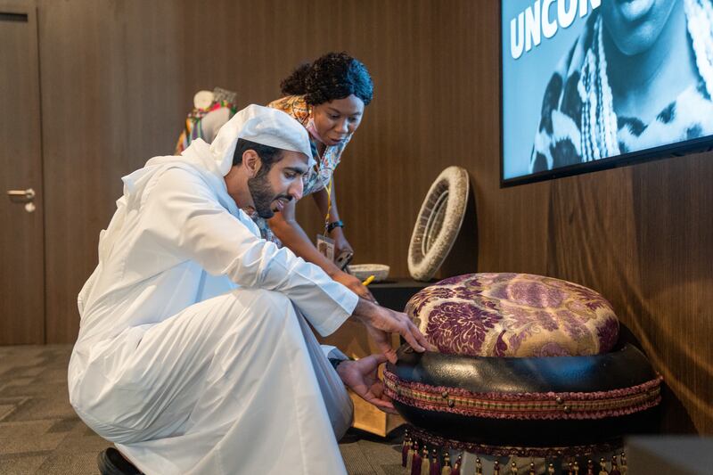 Sheikh Shakhbout examines a piece of traditional art at one of the African pavilions.