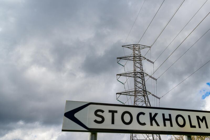 A road traffic sign, indicating the direction to central Stockholm, stands in view of a pylon near the University of Stockholm, Sweden, on Monday, May 6, 2019. Electricity capacity issues could hit an economy already heading south after years of strong growth buoyed by household spending and exports. Photographer: Mikael Sjoberg/Bloomberg