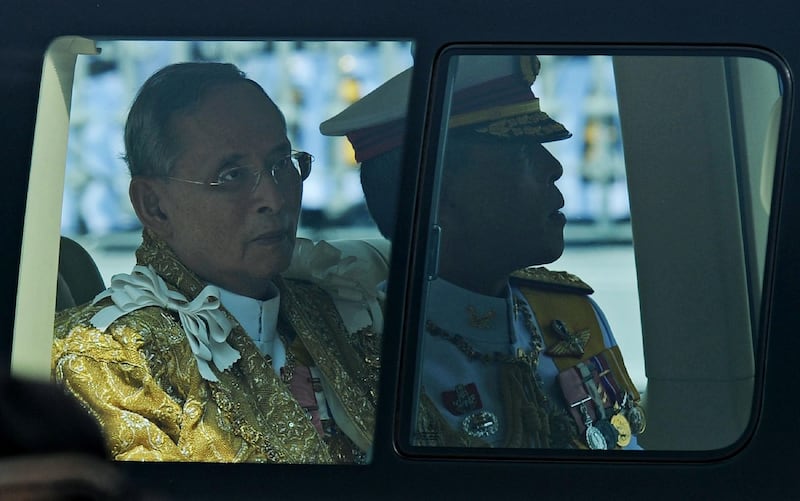 The former Thai king and King Vajiralongkorn sit in a royal limousine.  AFP