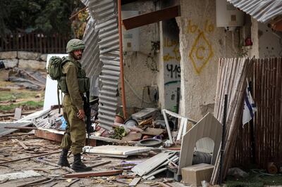 An Israeli soldier stands outside a destroyed home in Kibbutz Kfar Aza, one of the communities attacked by Palestinian Hamas militants on October 7. AFP