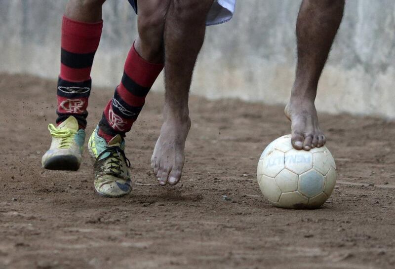 Players battle for the ball during a Sunday “pelada” soccer match in the Borel favela of Rio de Janeiro, a World Cup host city, May 4, 2014. Ricardo Moraes/ Reuters