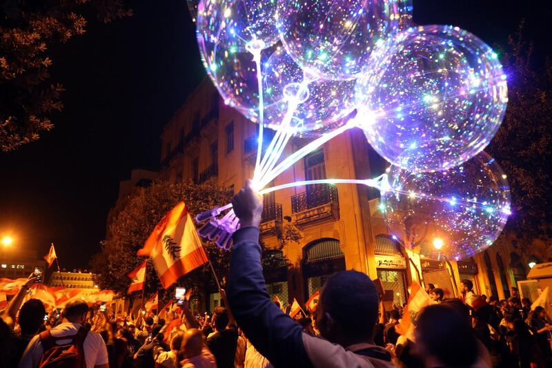 A street vendor carries balloons for sale during an anti-government demonstration in Beirut. Bloomberg