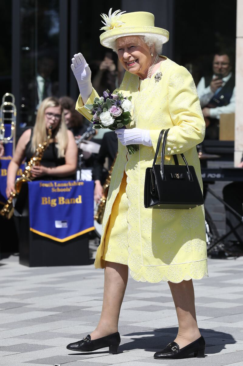 Queen Elizabeth II, wearing yellow, waves to the crowds during a visit to Greenfaulds High School on June 28, 2019, in Cumbernauld, Scotland. Getty Images