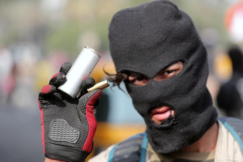 A demonstrator shows the casings from bullets and a tear gas canister which were allegedly used by the Iraqi security forces during ongoing anti-government protests in Baghdad. REUTERS