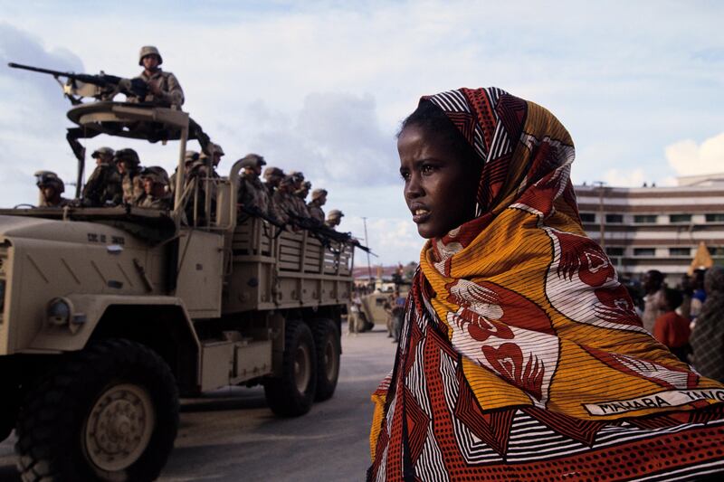 09 Dec 1992, Mogadishu, Somalia --- A adolescent girl watches with apprehension as US Marines recapture the American embassy in Mogadishu during Operation Restore Hope, a US-led mission to restore stability and protect United Nations humanitarian workers during the Somalian Civil War. With the end of President Mohammed Said Barre's dictatorship in 1991, Somalia plunged into a violent civil war, resulting in widespread famine and the starvation of hundreds of thousands of people before a tenuous peace was established with Operation Restore Hope. --- Image by © Les Stone/Sygma/Corbis *** Local Caption ***  rv14se-fiction main .jpg