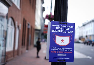 A sign on a lamppost requests people to wear face coverings in the Georgetown district of Washington, DC on June 22, 2020. Washington, DC begins Phase Two of reopening on June 22, 2020. as additional restrictions have been lifted on restaurants, nonessential businesses and houses of worship, among others. / AFP / MANDEL NGAN
